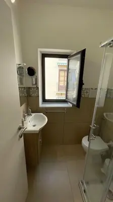 a bathroom with a sink and a toilet and a window at caZA' Capo 40MQ nel centro di Palermo in Palermo