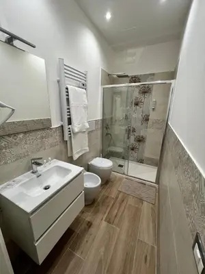 a bathroom with a sink and a toilet and a shower at Aragona House in Palermo
