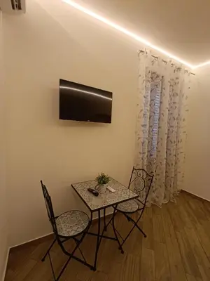 a dining room with a table and chairs and a television at Balarm Central Apartment in Palermo