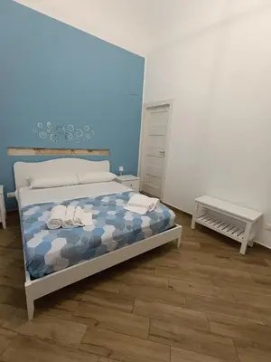 a bedroom with a bed with a blue wall at Balarm Central Apartment in Palermo