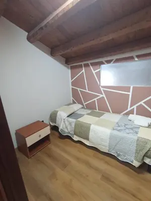 a bedroom with two beds and a wooden floor at B&b da Ely in Ventimiglia di Sicilia