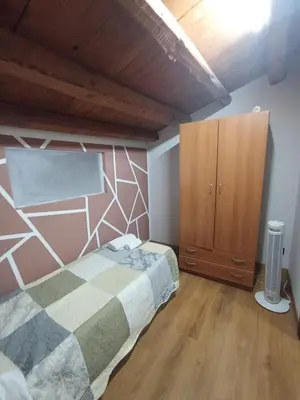 a bedroom with a bed and a wooden cabinet at B&b da Ely in Ventimiglia di Sicilia