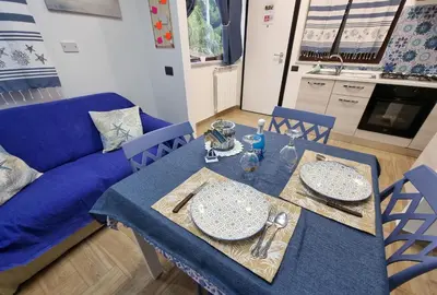 a dining table with a blue table cloth and a blue couch at Vida Loca -Appartamento vicino aereporto e 200mt spiaggia in Carini