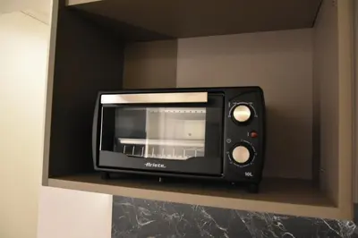 a black toaster oven sitting on a shelf at Cilea Apartments in Palermo
