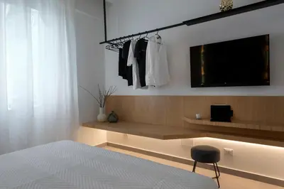 a bedroom with a bed and a tv and a chair at Cilea Apartments in Palermo