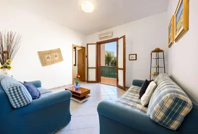 a living room with two blue couches and a table at I Tre Golfi - Pianeti in San Vito lo Capo