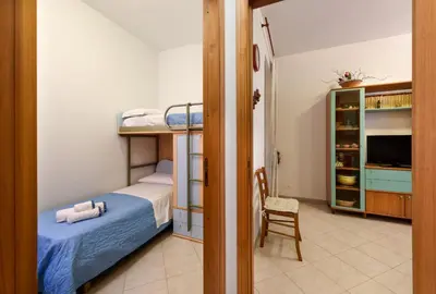 a bedroom with two bunk beds and a chair at I Tre Golfi - Pianeti in San Vito lo Capo