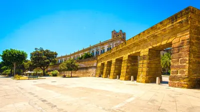a large stone wall with a building in the background at Kalsa miniLoft by Wonderful Italy in Palermo