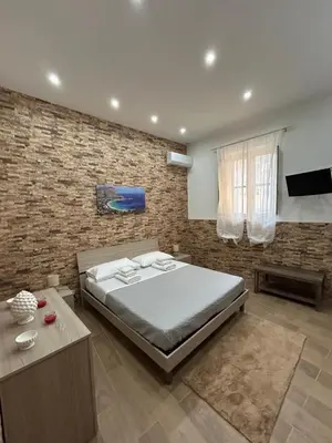 a bedroom with a bed and a brick wall at Home Love in Palermo