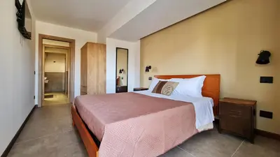 a bedroom with a large bed with a pink blanket at The blue and red rooms in Bagheria