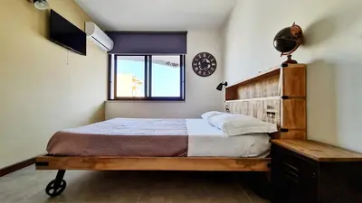 a bedroom with a wooden bed and a window at The blue and red rooms in Bagheria