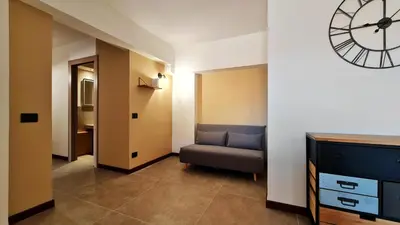 a room with a couch and a clock on the wall at The blue and red rooms in Bagheria