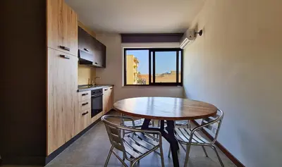 a small kitchen with a wooden table and two chairs at The blue and red rooms in Bagheria