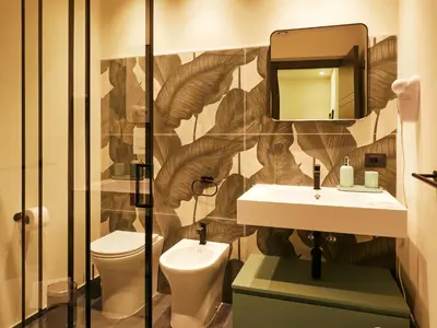 a bathroom with a toilet and a sink and a mirror at HUB Rooms in Carini
