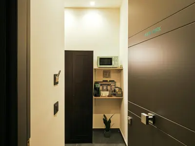 a door leading to a room with a microwave at HUB Rooms in Carini