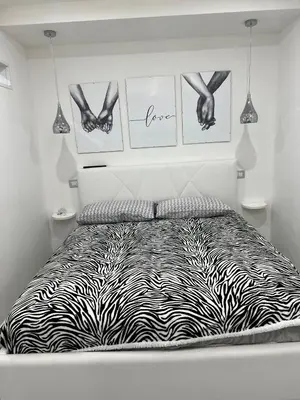a bedroom with a zebra print bed with pictures on the wall at Pietro Fudduni Apartment in Palermo