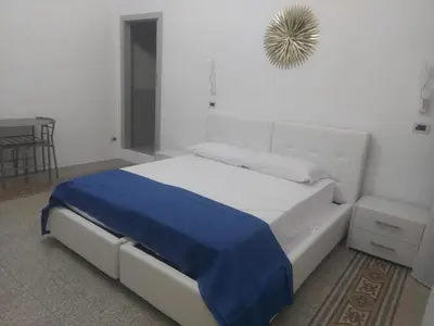 a bedroom with a bed with a blue blanket on it at Guest House Militello in Palermo