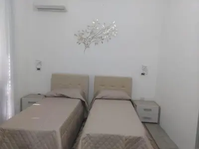 two beds in a room with white walls at Guest House Militello in Palermo