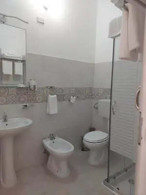 a white bathroom with a toilet and a sink at Guest House Militello in Palermo