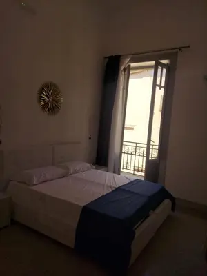 a bedroom with a large bed with a window at Guest House Militello in Palermo