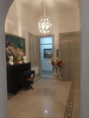 a hallway with a room with a piano and a chandelier at Guest House Militello in Palermo