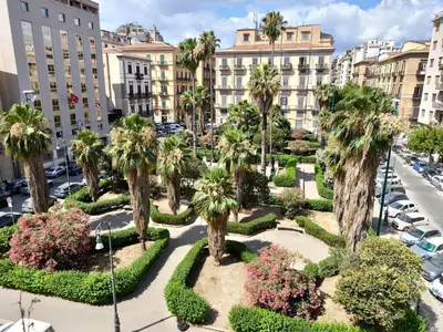 an aerial view of a park with palm trees and buildings at Mansarda Florio in Palermo