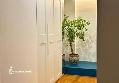 a hallway with a door with a potted plant at Mansarda Florio in Palermo