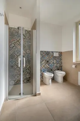 a bathroom with a glass shower and a toilet at Mondello House in Palermo