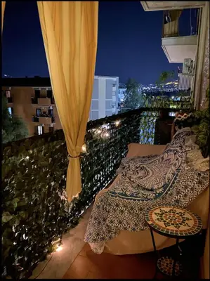 a balcony with a table and a curtain and lights at Dolce Sicily a 2km dal centro in Palermo