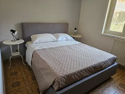 a bedroom with a bed and two tables with lamps at Guests's Nest in Castellammare del Golfo