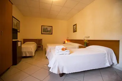 a room with two beds with white sheets at Albergo La Principessa in Alcamo