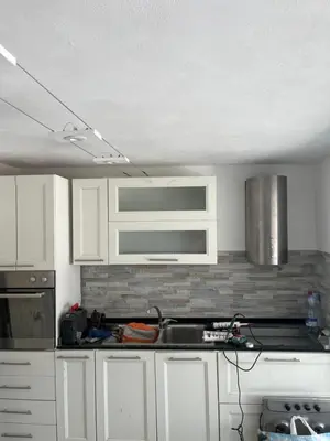 a kitchen with white cabinets and a stove top oven at Casa vacanze Giada in Terrasini
