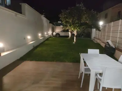 a white table and chairs in a yard at night at Casa vacanze Casuzza Sferracavallo Palermo in Palermo