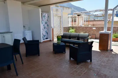 a patio with black chairs and a table and a view at La Casetta di Ale in Isola delle Femmine