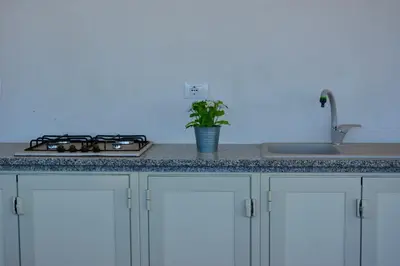 a kitchen counter with a stove and a sink at La Casetta di Ale in Isola delle Femmine