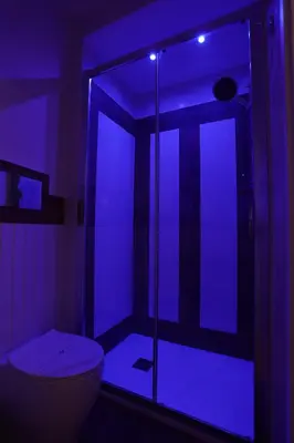 a bathroom with a toilet and a blue light at De Spuches House in Caccamo
