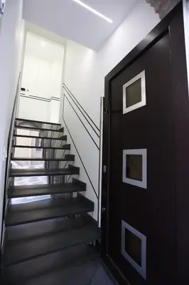 a hallway with stairs and a black door at De Spuches House in Caccamo