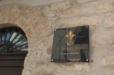 a sign on the side of a stone building at De Spuches House in Caccamo