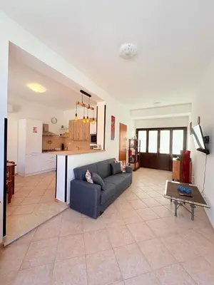 a living room with a couch and a kitchen at Casa Joe in San Vito lo Capo