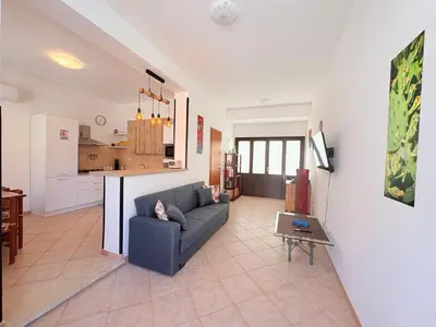a living room with a couch and a kitchen at Casa Joe in San Vito lo Capo