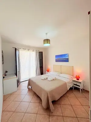 a bedroom with a large bed and a table and a window at Casa Joe in San Vito lo Capo