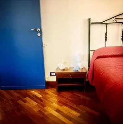 a bedroom with a bed and a blue door at Casa del Blu in Palermo