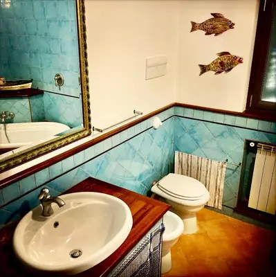 a bathroom with a sink and a toilet and a mirror at Casa del Blu in Palermo