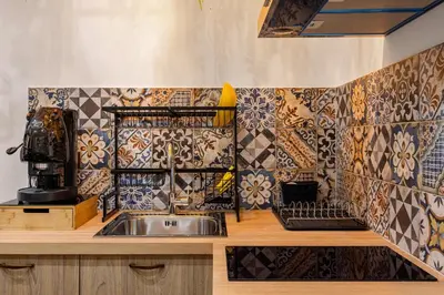 a kitchen with a sink and tiles on the wall at Luxury House Ballarò in Palermo