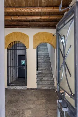 a staircase in a building with two arches and a stair case at Luxury House Ballarò in Palermo