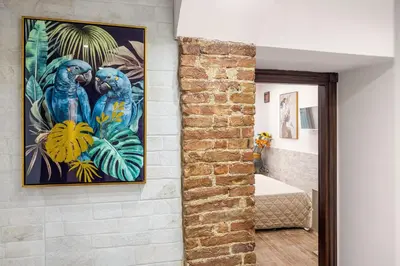 a painting of two blue parrots hanging on a wall at Luxury House Ballarò in Palermo