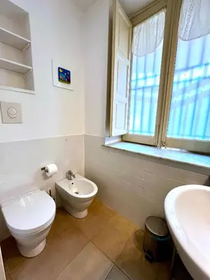a bathroom with a toilet and a sink and a window at Casetta Bontà in Palermo