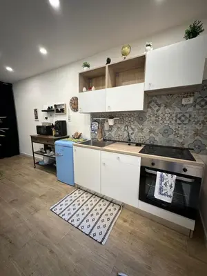 a kitchen with white cabinets and a stove at Scillò House in Palermo