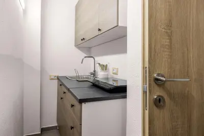 a kitchen with a counter with a sink and a door at G e B Central Apartment in Palermo