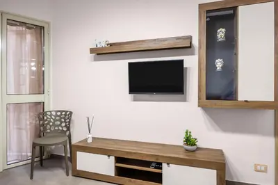 a living room with a table and a tv on a wall at G e B Central Apartment in Palermo